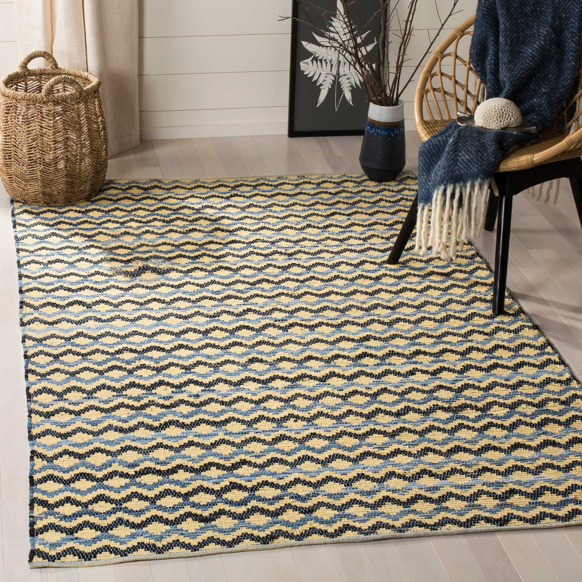 Golden cotton rug brings black and blue zigzag rhythm and woven warmth to the floor