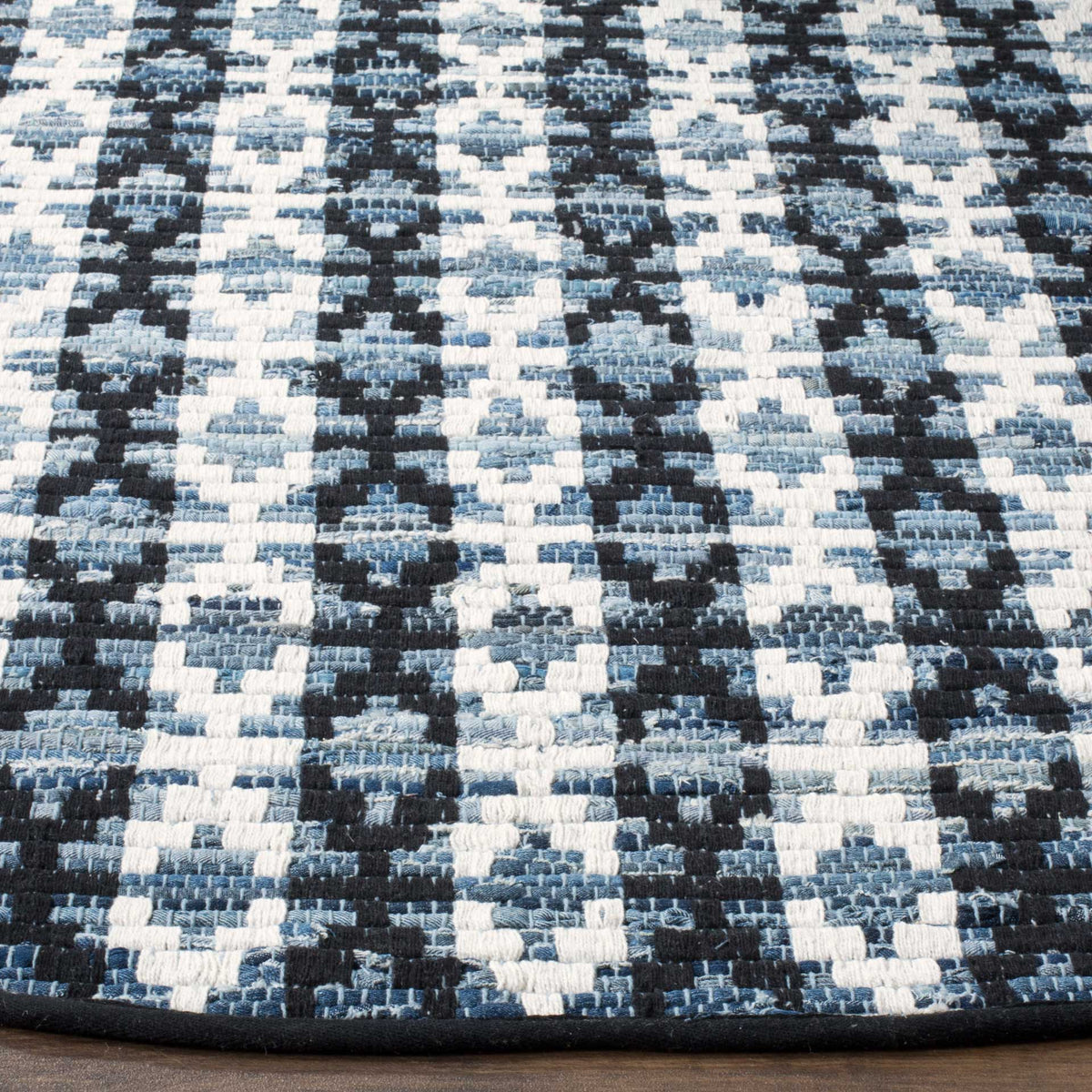 Black and blue woven shapes contrast with ivory threads and a neatly bound dark edge