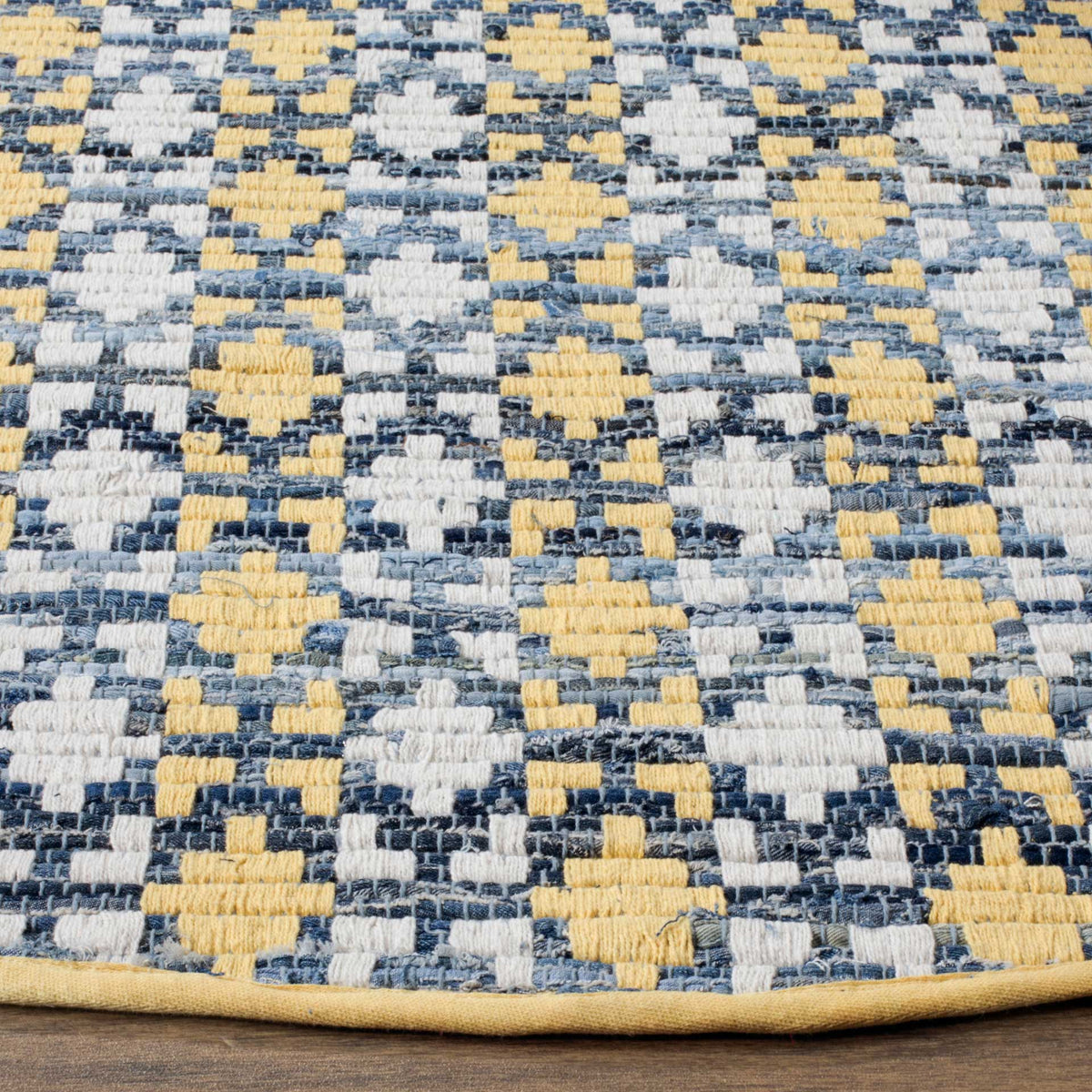 Golden yellow shapes stand out against a textured blue-and-ivory weave and neatly finished edge