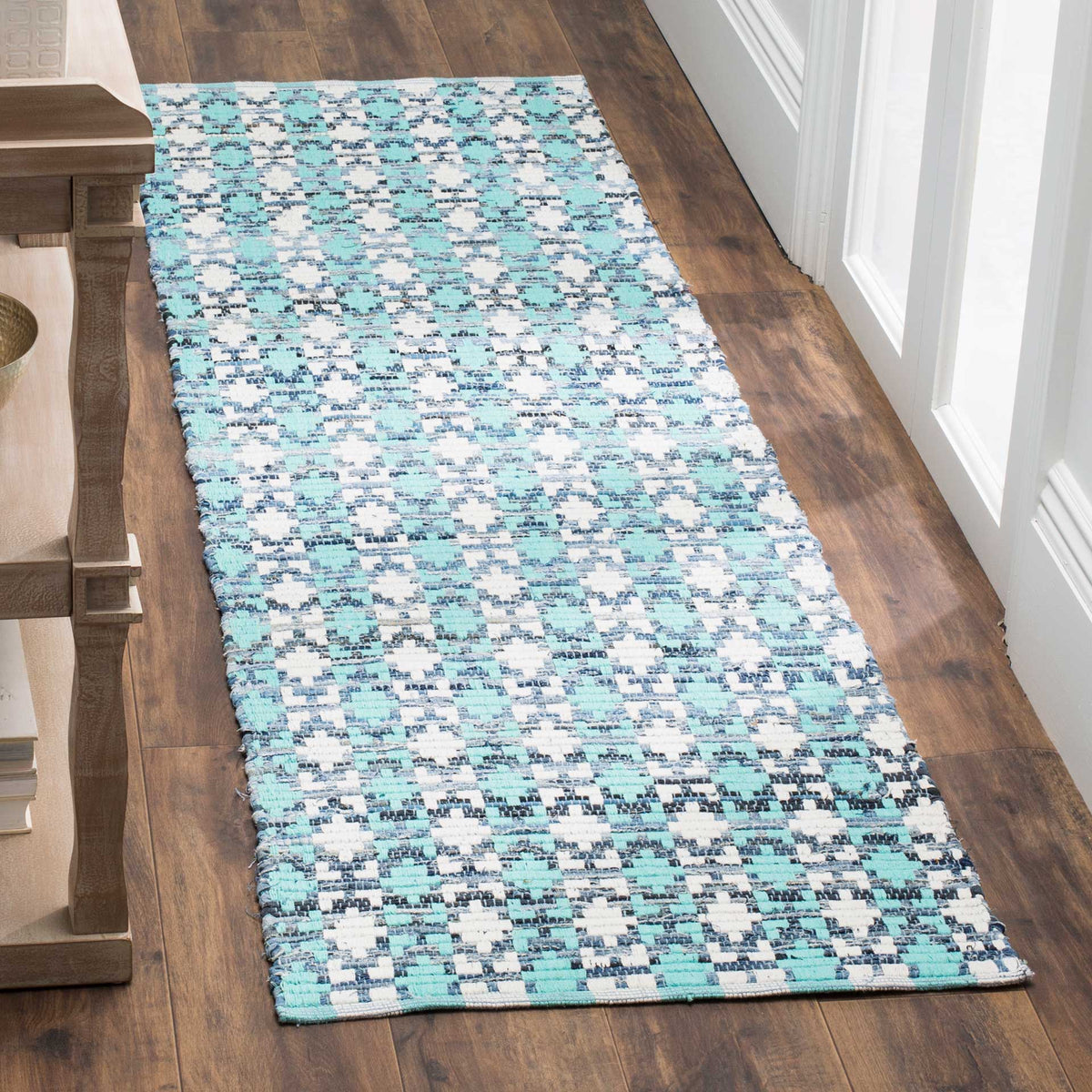 Cool turquoise and deep blue details ripple across this textured ivory cotton runner.
