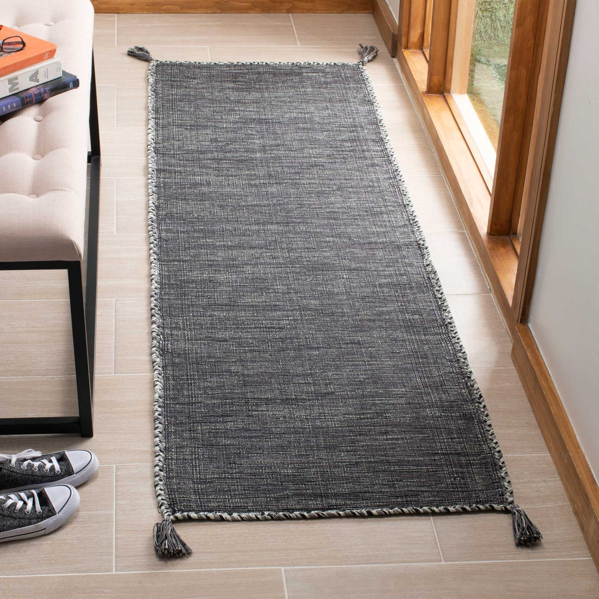Heathered gray and black weave gives this slender runner depth, framed by corded trim and tassels