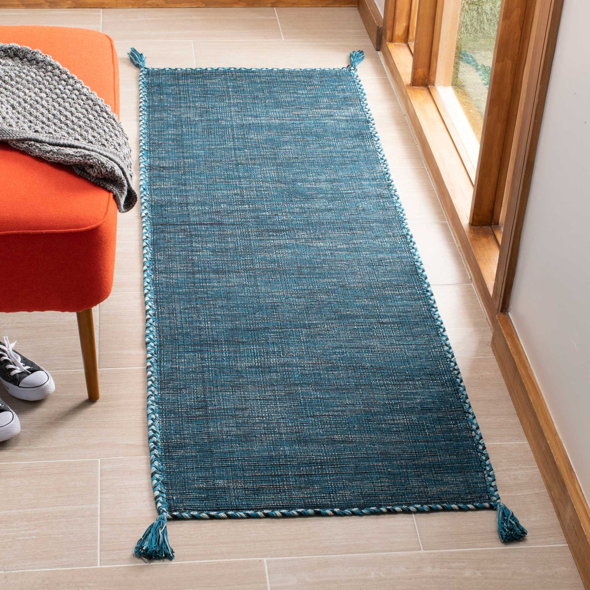 Deep blue threads mingle with black on a slim woven runner with corded edges and playful tassels