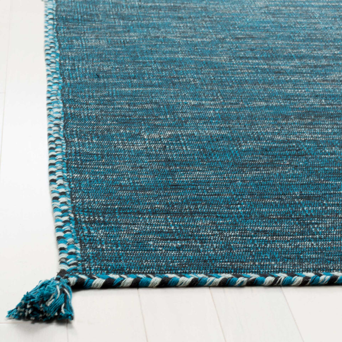 Braided blue and black trim meets a heathered cotton weave and a plush corner tassel.