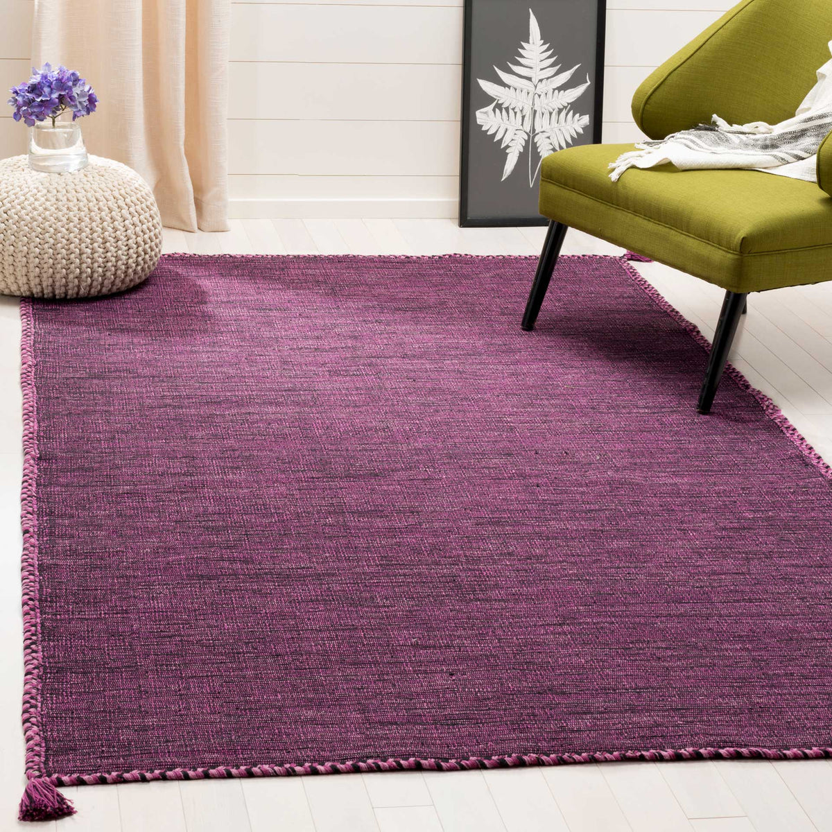 The purple and black cotton rug gives a seating area vivid color and finely woven texture.