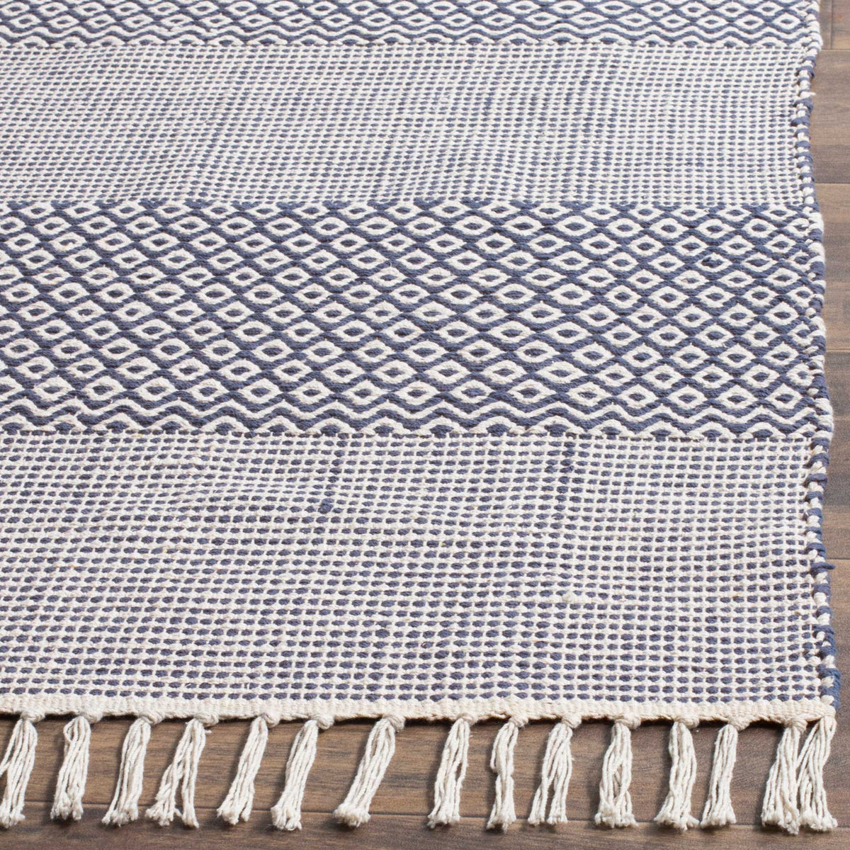 Deep navy diamonds and ivory woven stripes lead to a soft row of cotton tassels