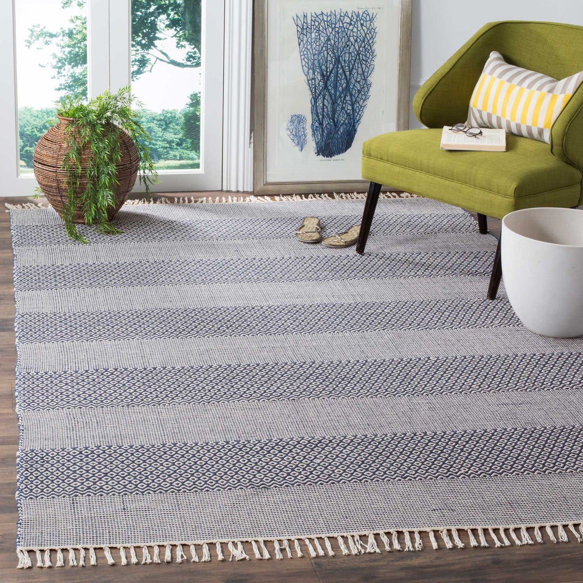 Ivory and navy rug adds graphic geometric stripes and soft fringe to a seating area
