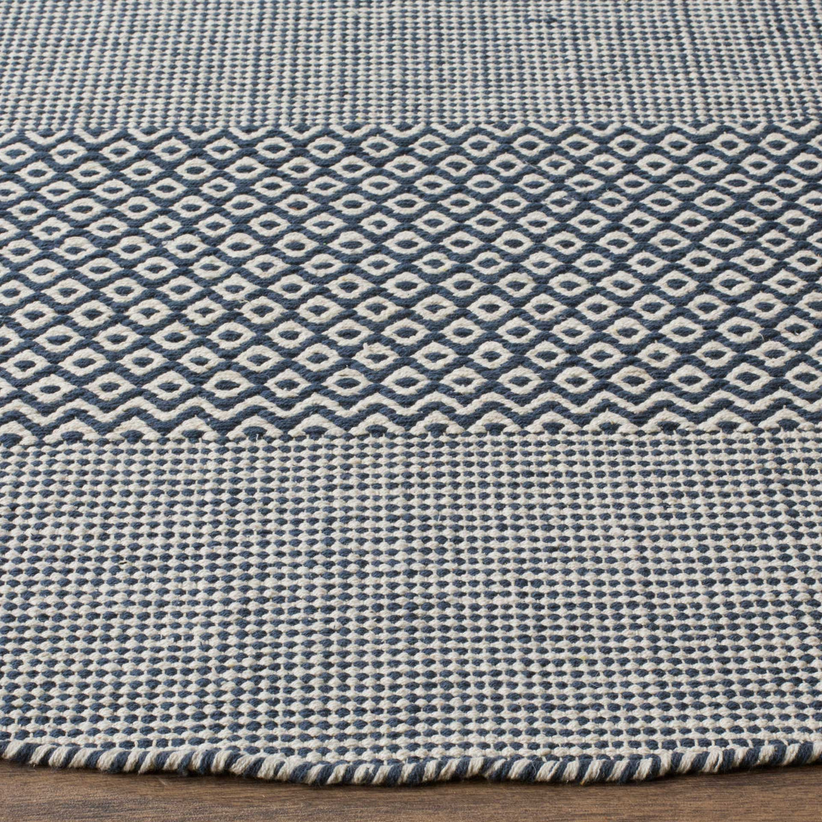 Navy diamond motifs and dense ivory cotton weave meet at a neatly finished edge