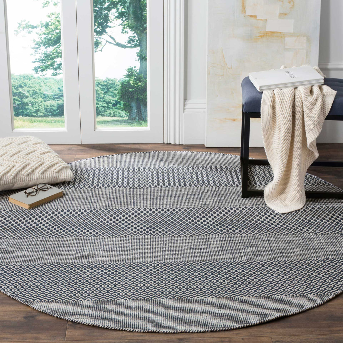 Round ivory and navy rug grounds a welcoming space with crisp geometric stripes