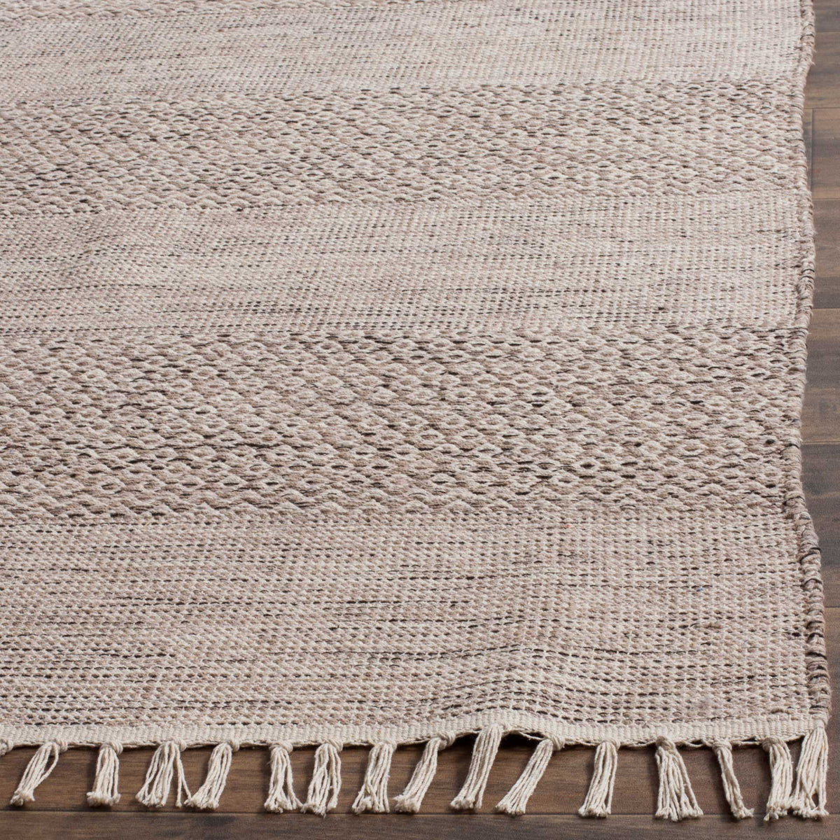 Tactile woven diamonds and subtle steel gray stripes meet knotted ivory fringe