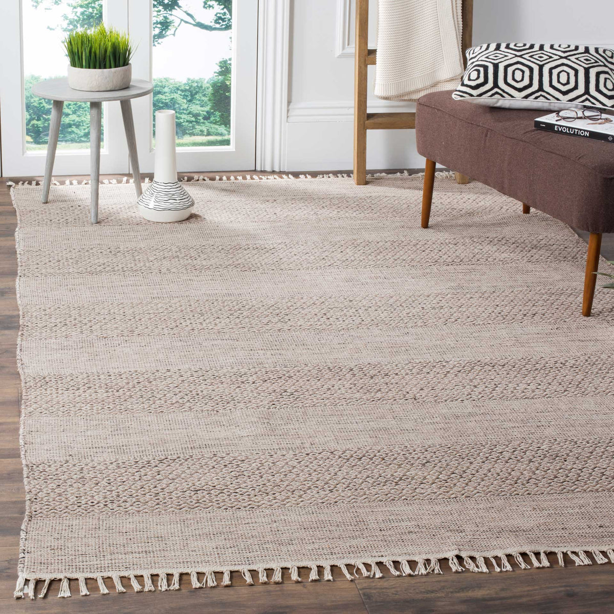 Ivory and steel gray cotton rug adds quietly patterned texture and fringe to a living room
