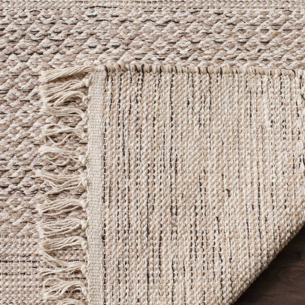 A folded cotton corner reveals the textured backing beneath soft gray and ivory bands