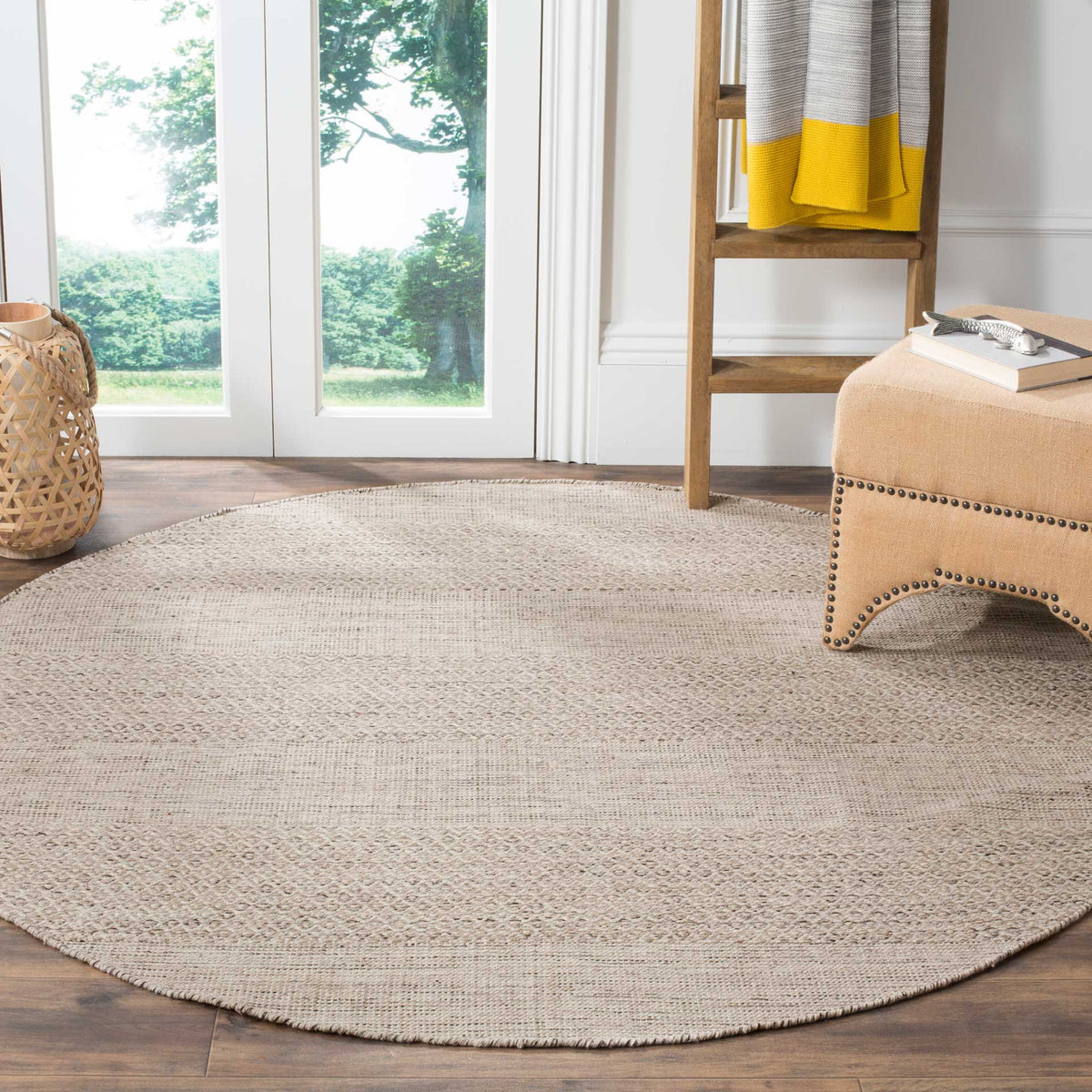 Round ivory and steel gray rug adds understated pattern and warmth to a bright living area