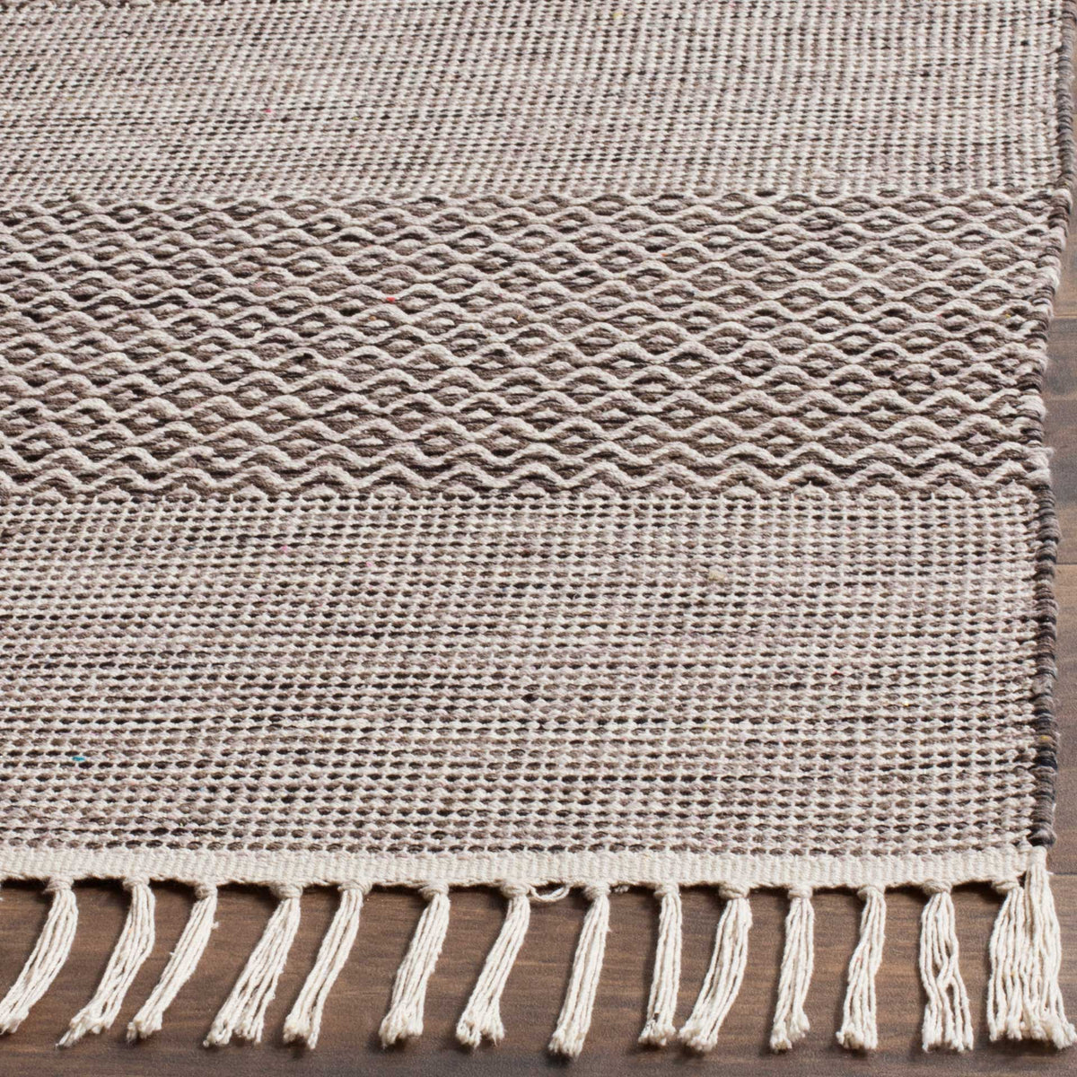 Anthracite diamond motifs, fine woven stripes, and ivory fringe add inviting texture