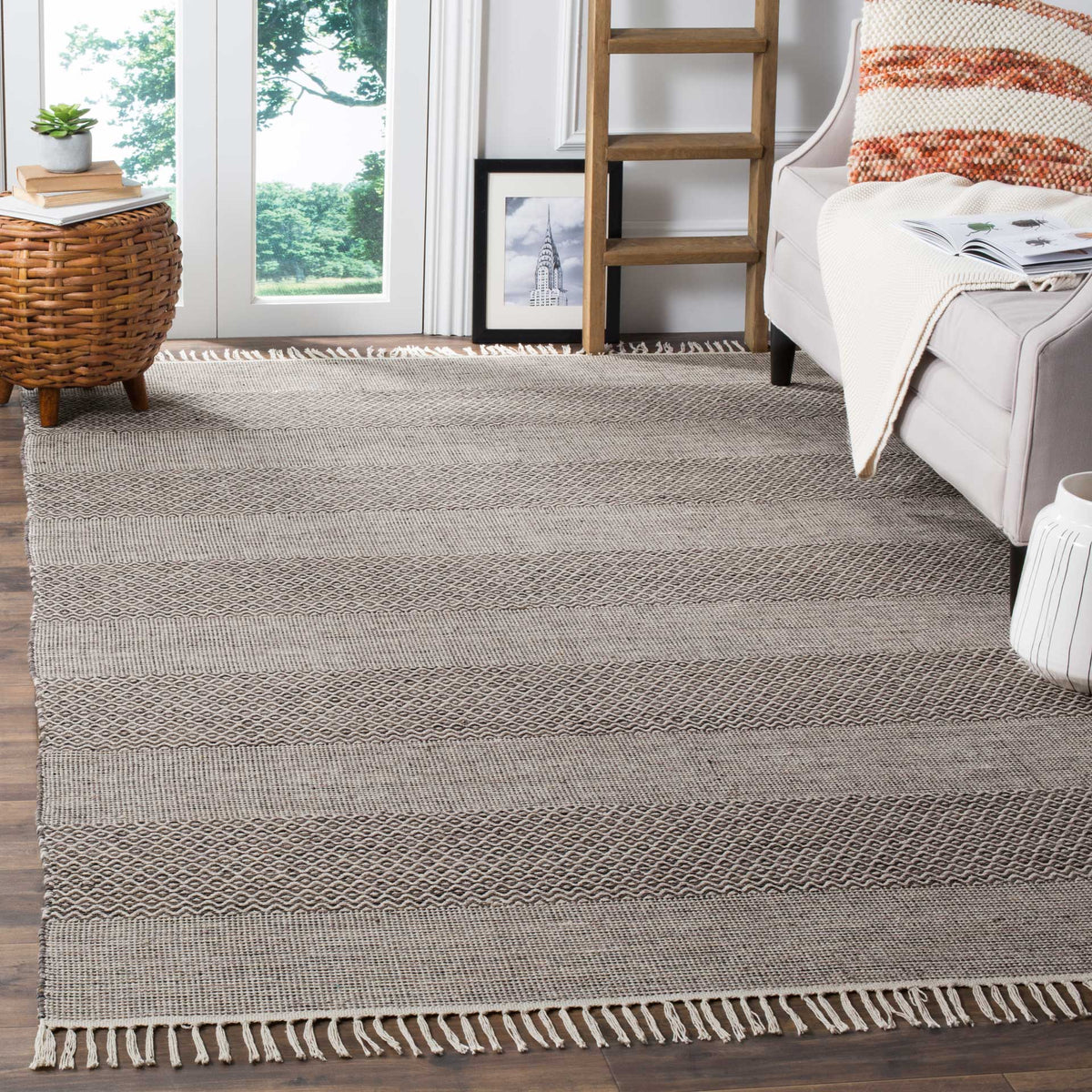 Ivory and anthracite cotton rug grounds a living space with geometric stripes and fringe