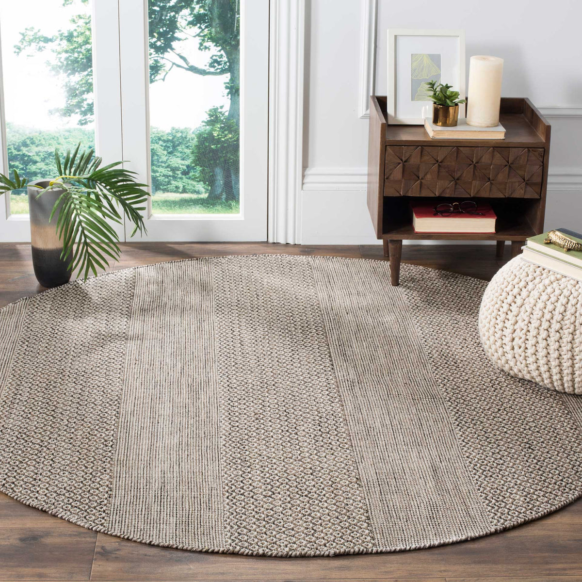 Round cotton rug brings ivory and anthracite geometric patterns to a bright living space