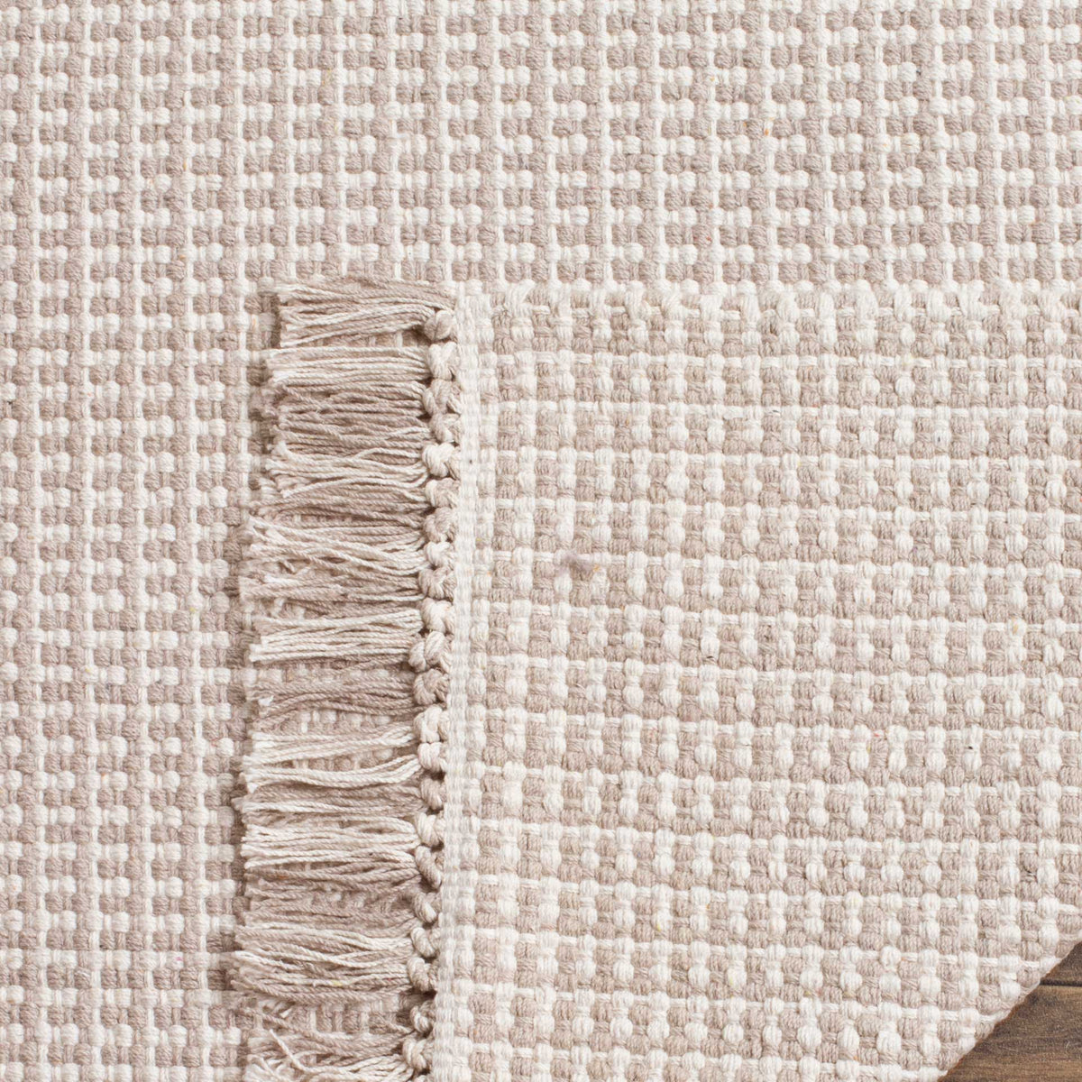 Ivory and gray cotton rug has a closely woven underside and soft fringe