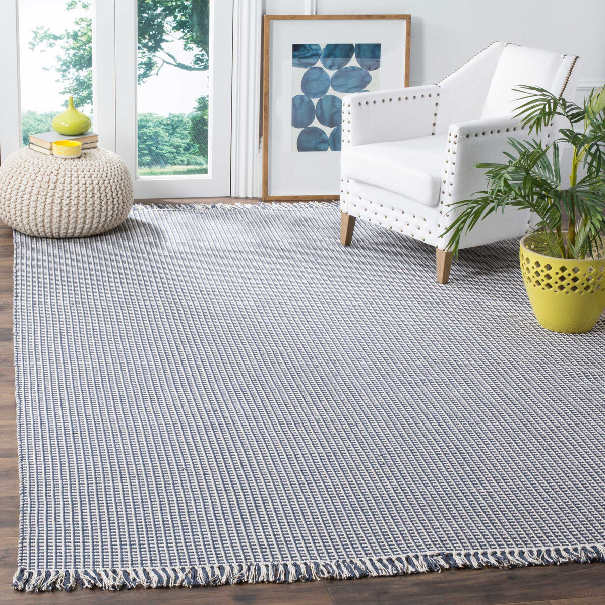 Navy and ivory woven rug anchors a bright seating area with crisp texture and tasseled trim