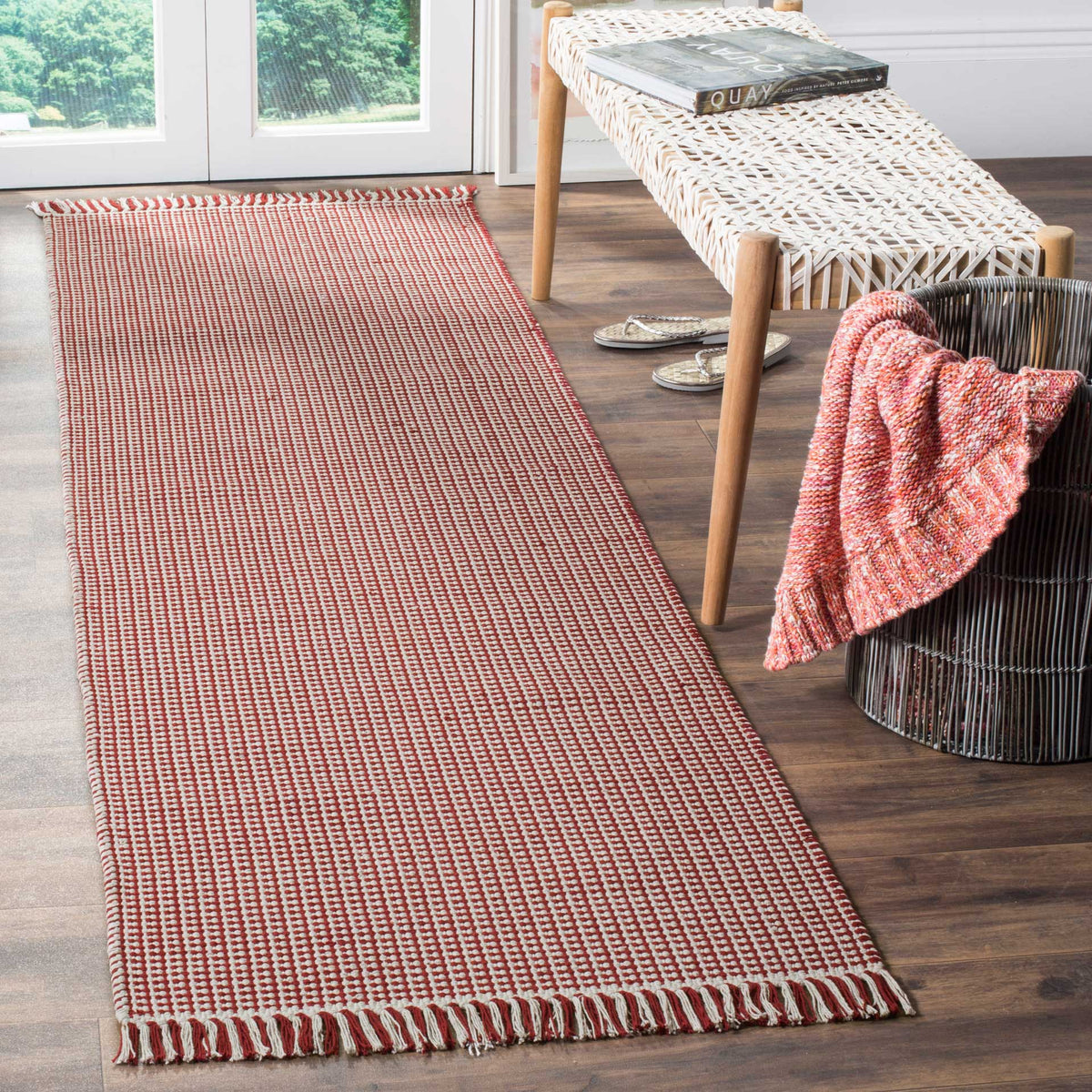 A warm red-and-ivory weave and bold fringed ends enliven this narrow cotton runner
