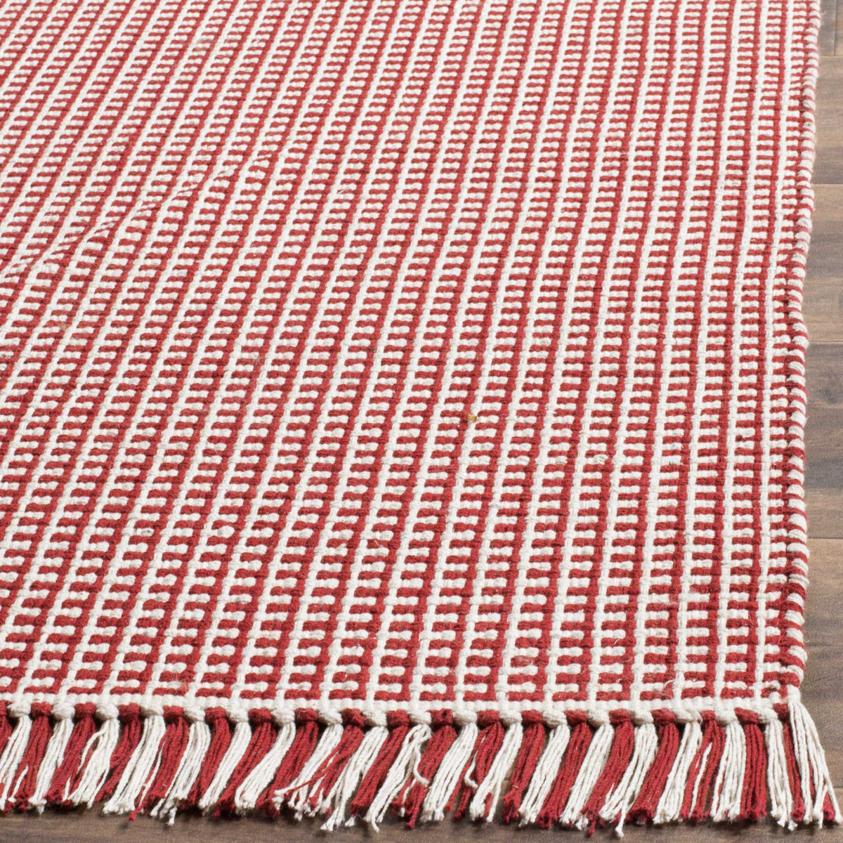 Bright red and ivory cotton yarns weave into a checked texture above a two-tone fringe