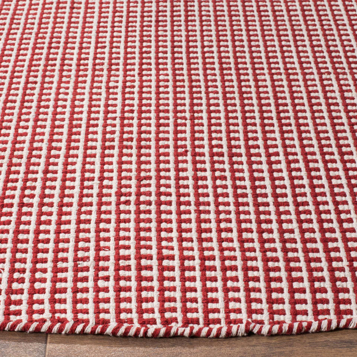 Red and ivory cotton yarns form bold, raised rows and a neatly finished edge