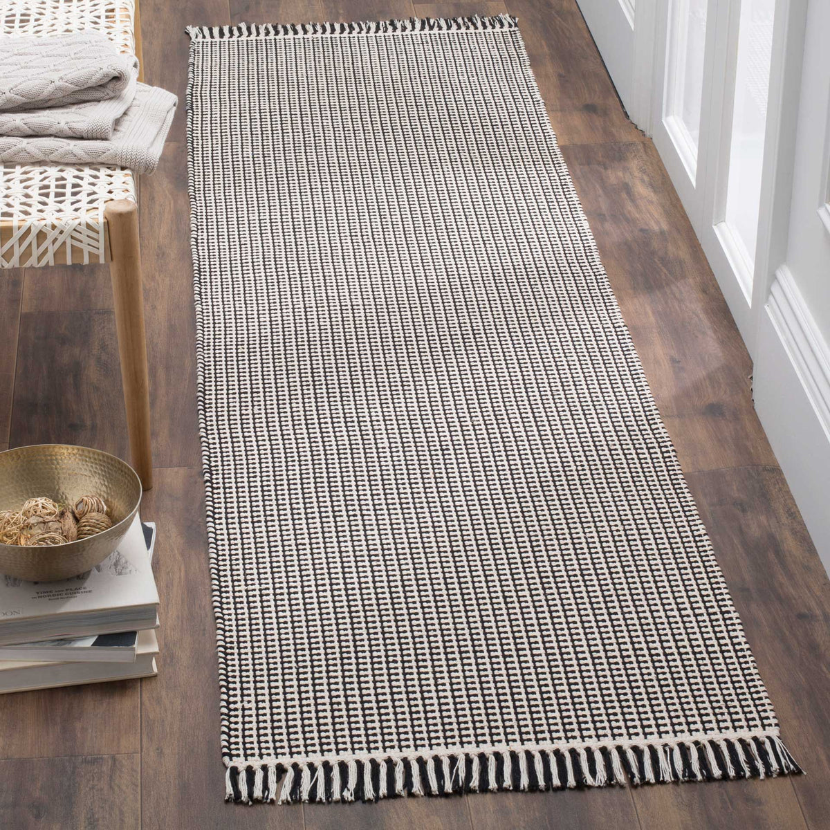 A slim ivory and black runner brings crisp woven texture and fringed ends to narrow spaces