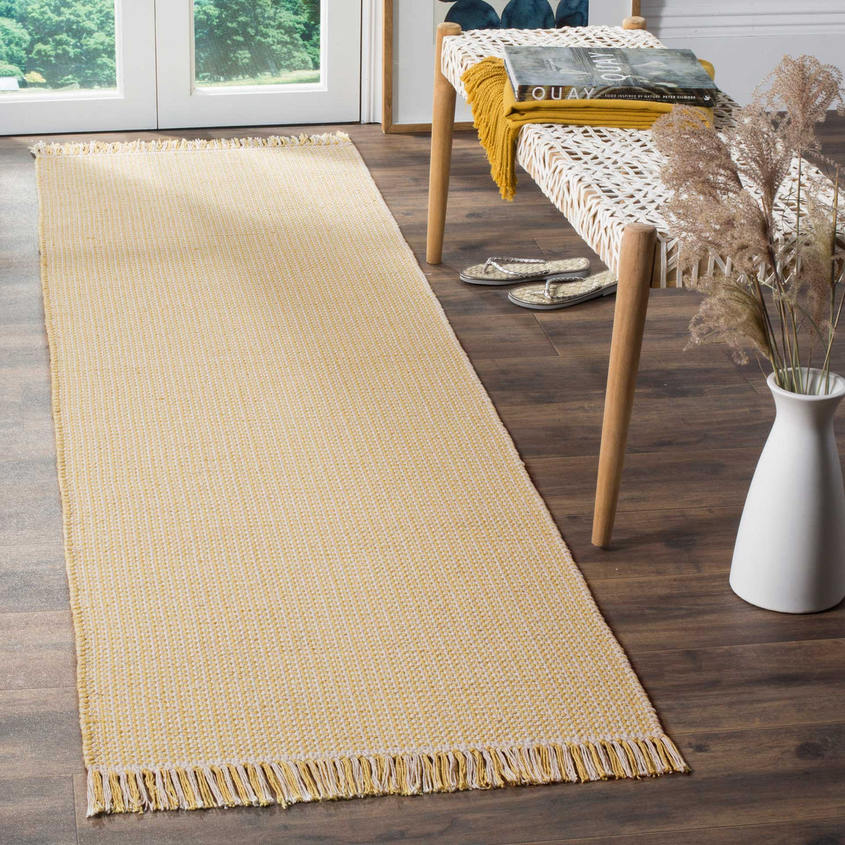 Warm yellow hues and playful fringe give this slim ivory cotton runner an inviting finish
