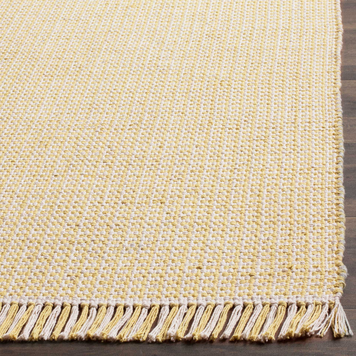 Raised ivory and yellow woven texture meets a matching tassel fringe at the rug's edge