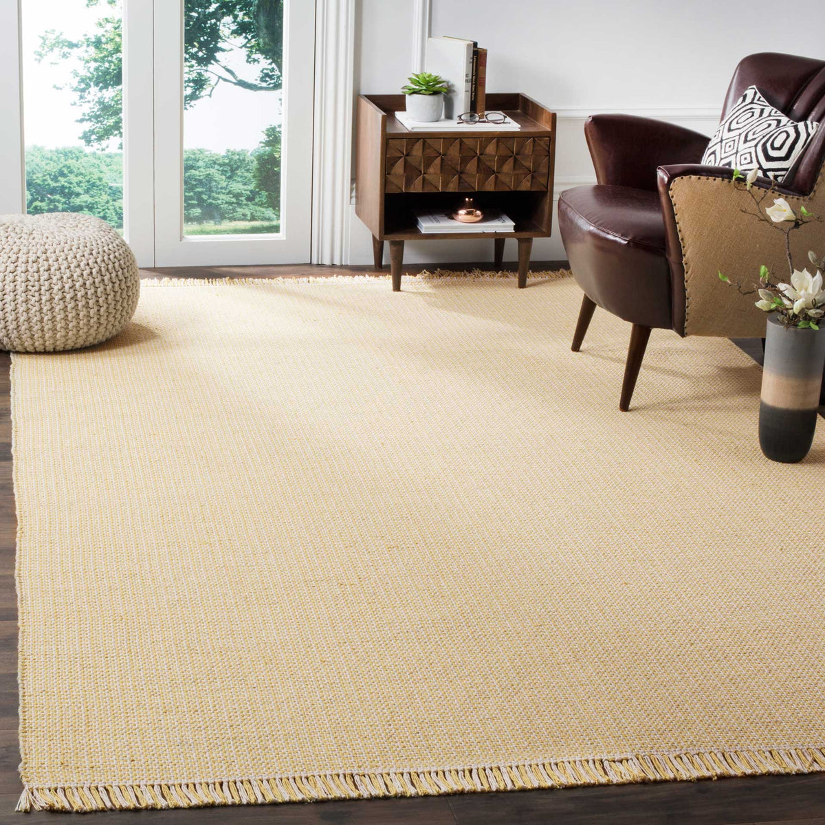Soft yellow and ivory rug lends a sunny accent to a sitting area with woven texture and fringe