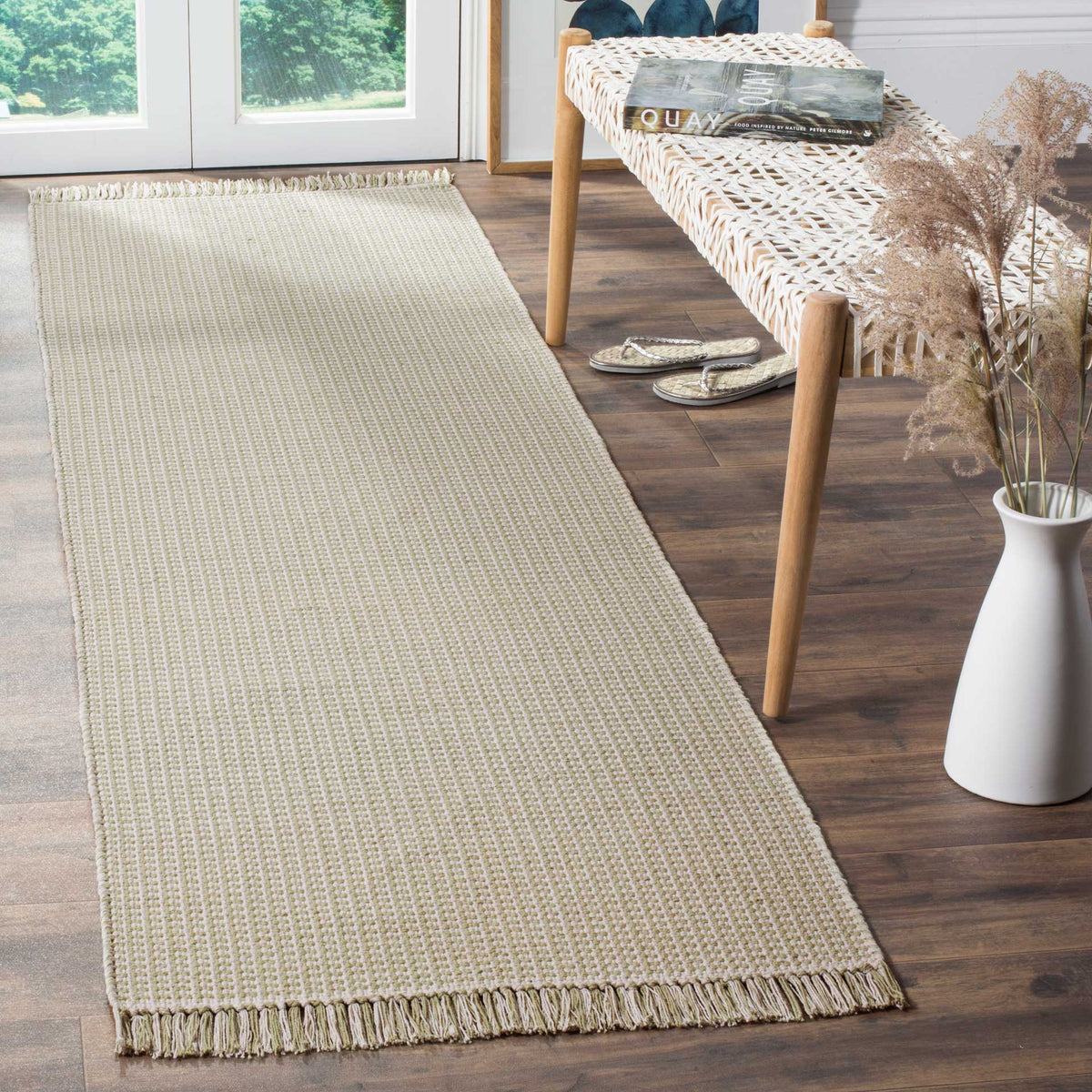 A hint of sage green and delicate fringe lends this narrow woven runner an airy feel