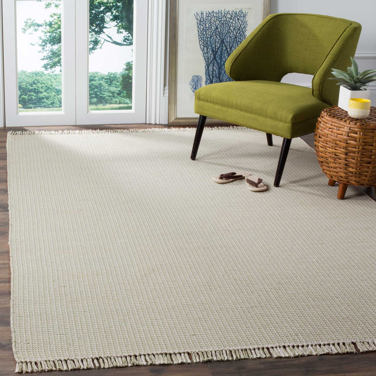 Soft green and ivory woven rug lends subtle texture and fringe to a bright reading nook