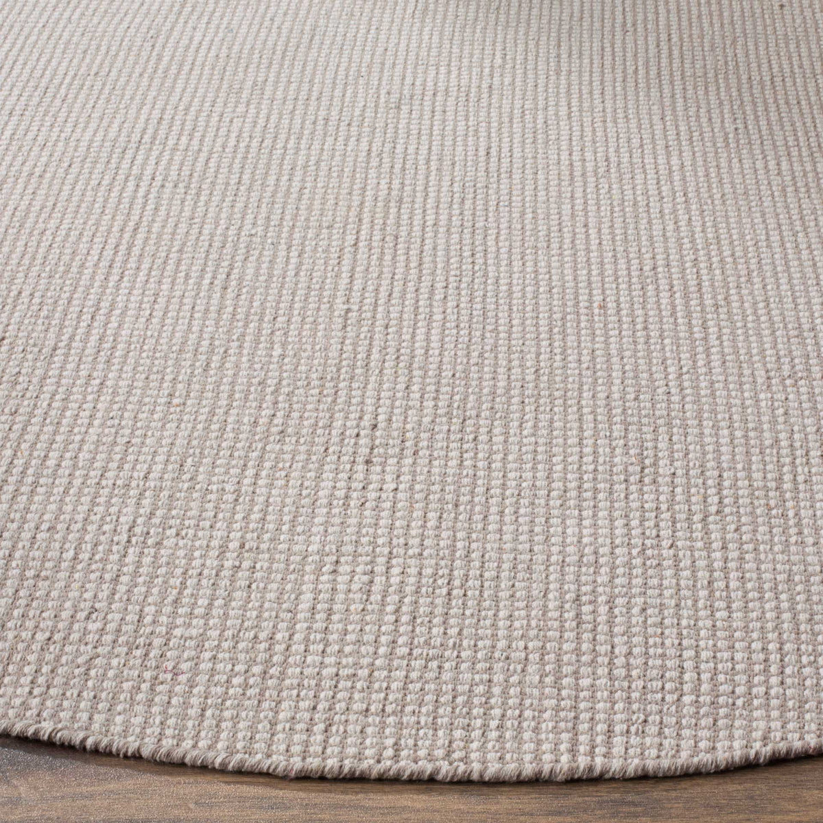 Handwoven ivory and gray yarns form a subtle texture with a neatly finished edge.