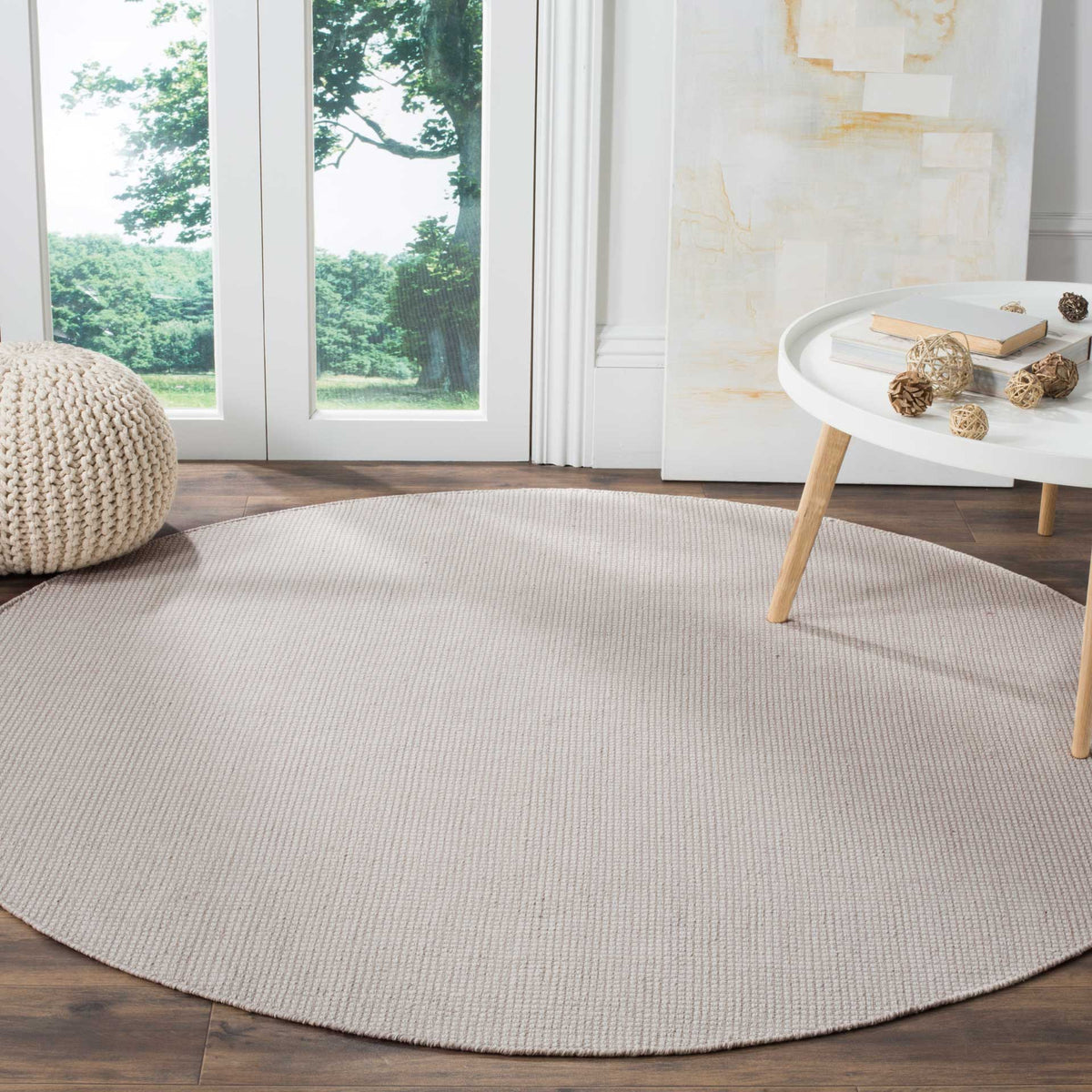 An ivory and gray round rug anchors the space with gentle color and woven cotton comfort.