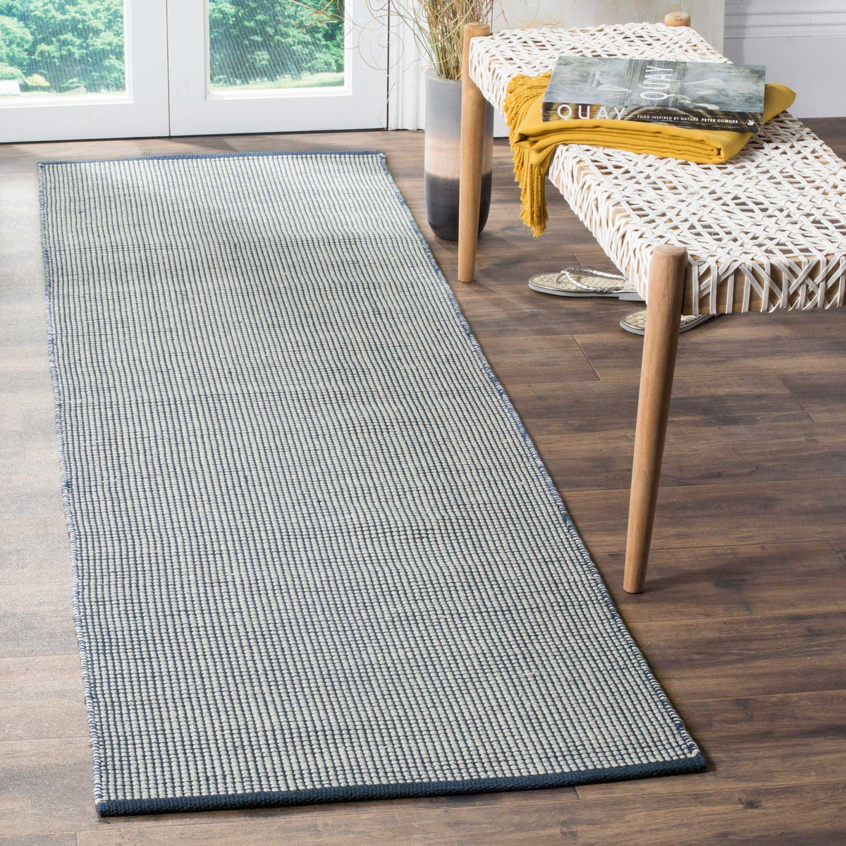 Handwoven ivory and navy runner brings fine texture and slim edging to narrow spaces.
