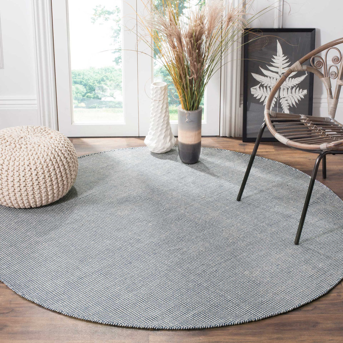 A navy and ivory round rug adds crisp contrast and soft cotton texture beneath a chair.