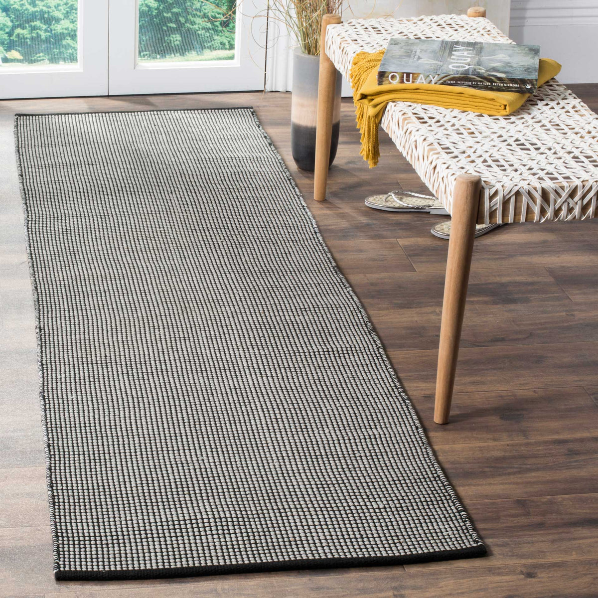 Low-profile ivory and black runner lends textured contrast and tailored edges to narrow spaces.