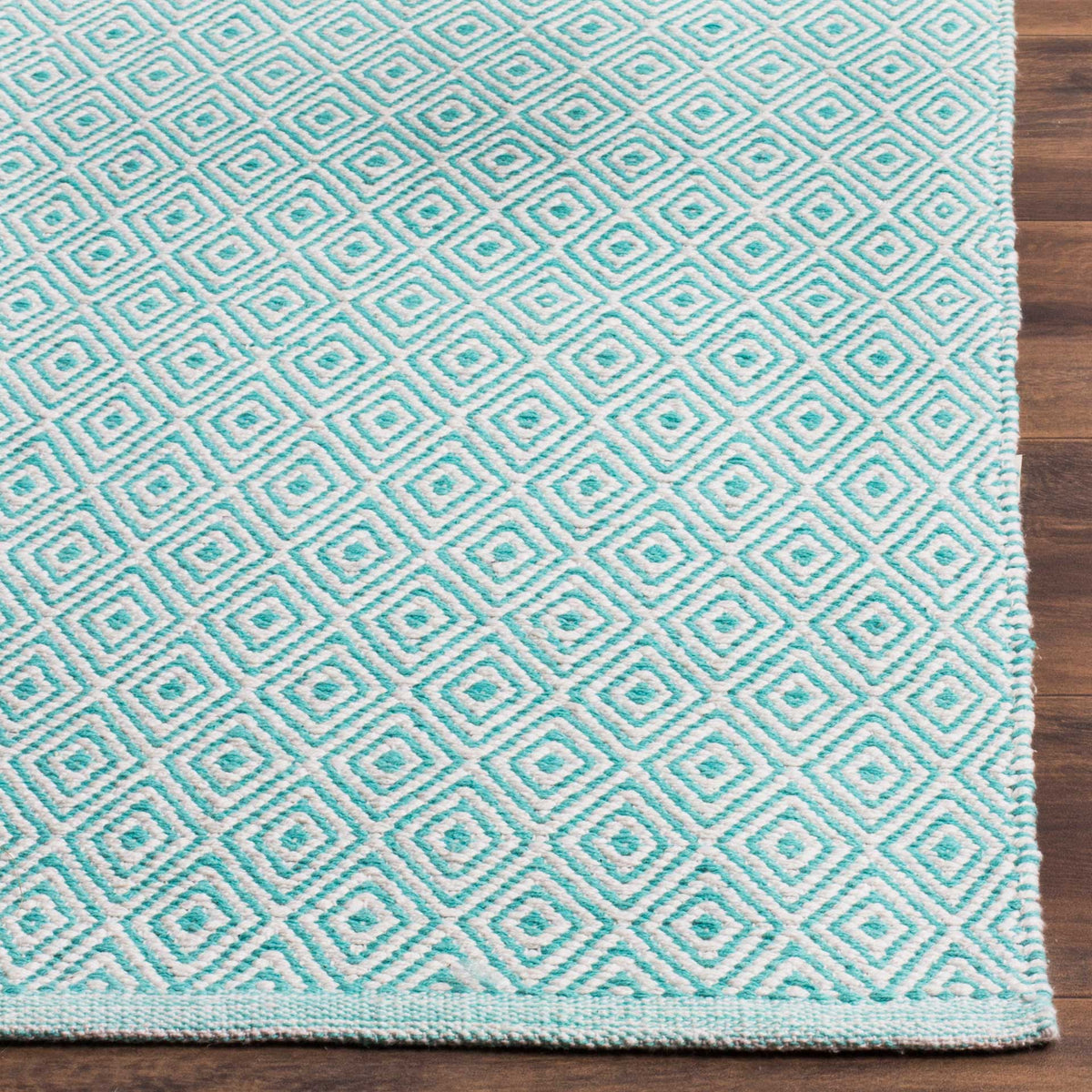 Aqua and ivory diamonds meet a neatly bound edge on this textured cotton rug