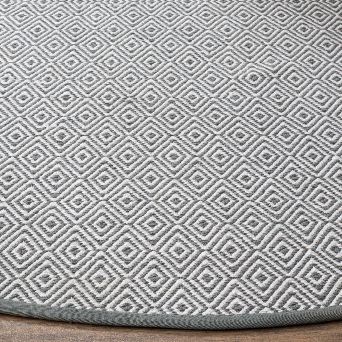 Tightly woven gray and ivory diamonds meet a neatly bound gray edge.