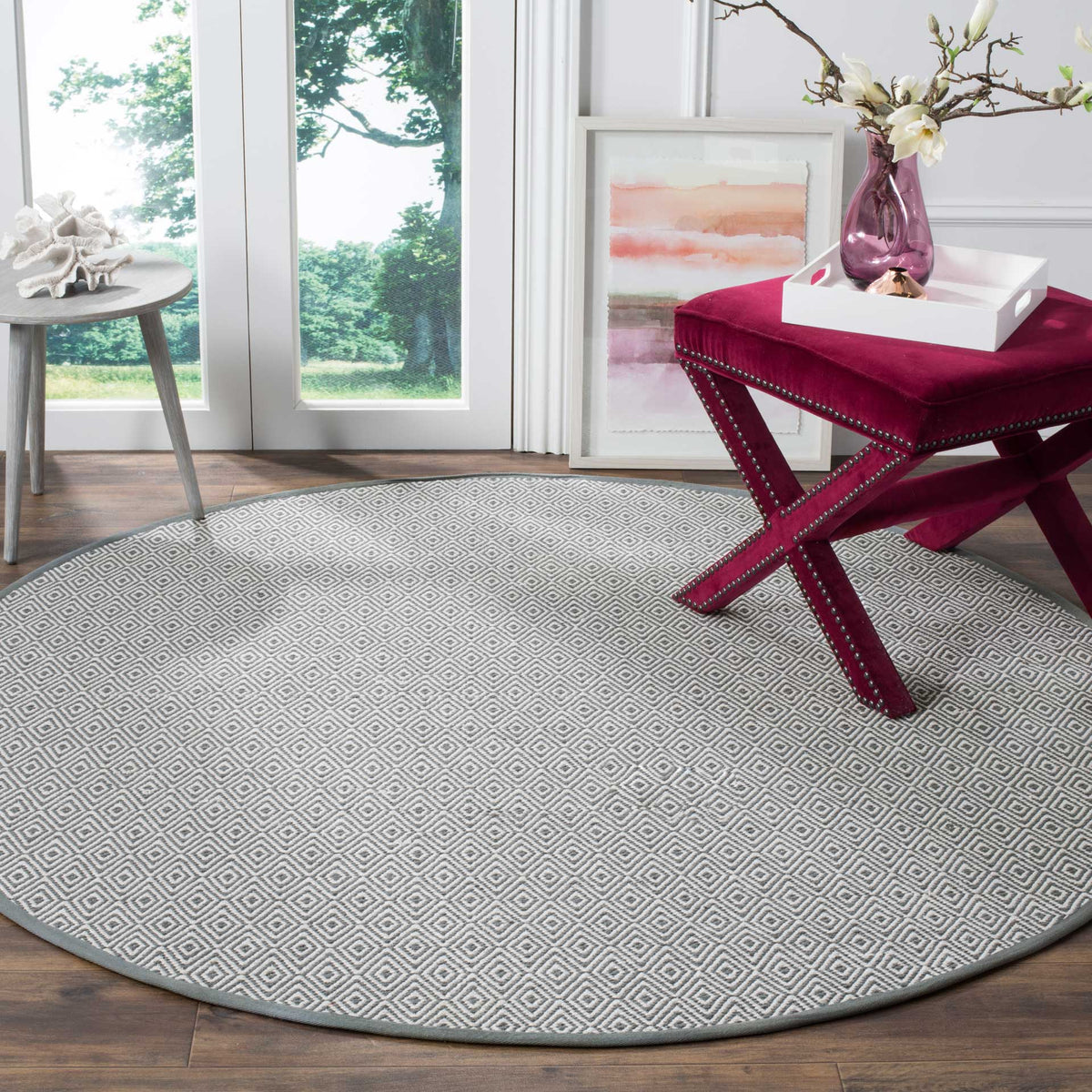 Gray and ivory diamond-patterned rug anchors a bright seating area.