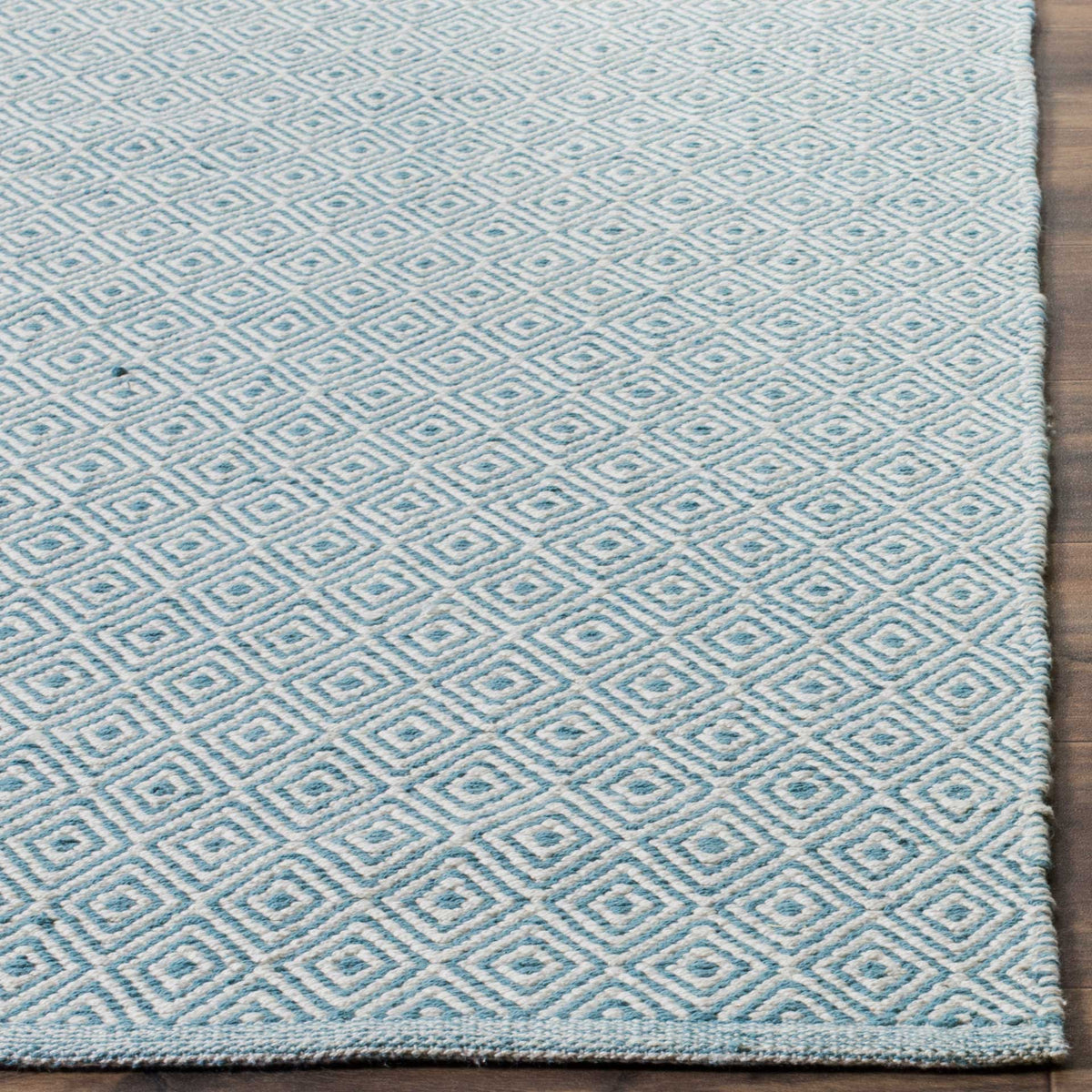 Light blue and ivory diamonds meet a narrow finished edge on this cotton rug