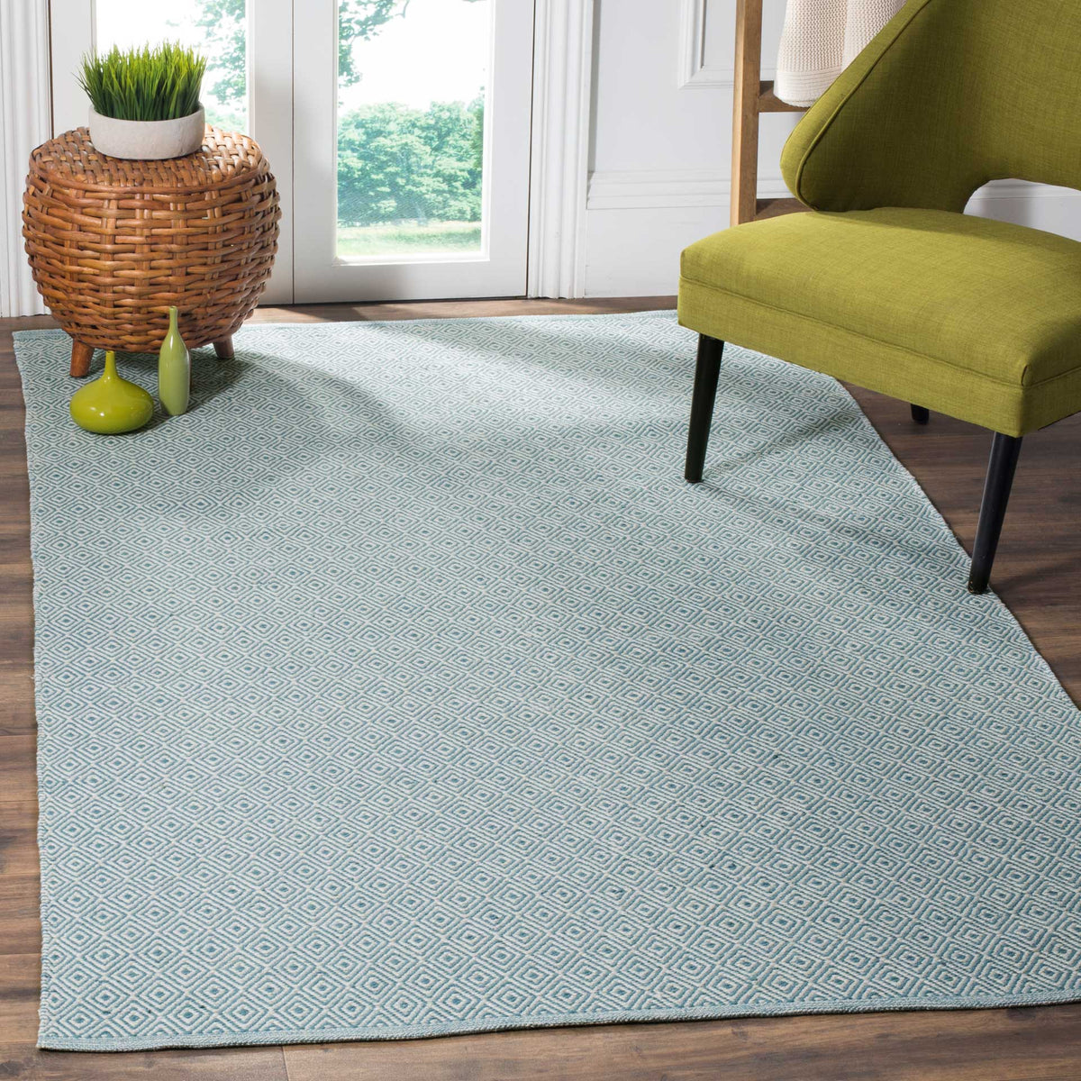 An ivory and light blue diamond rug sets a cool foundation beneath an accent chair