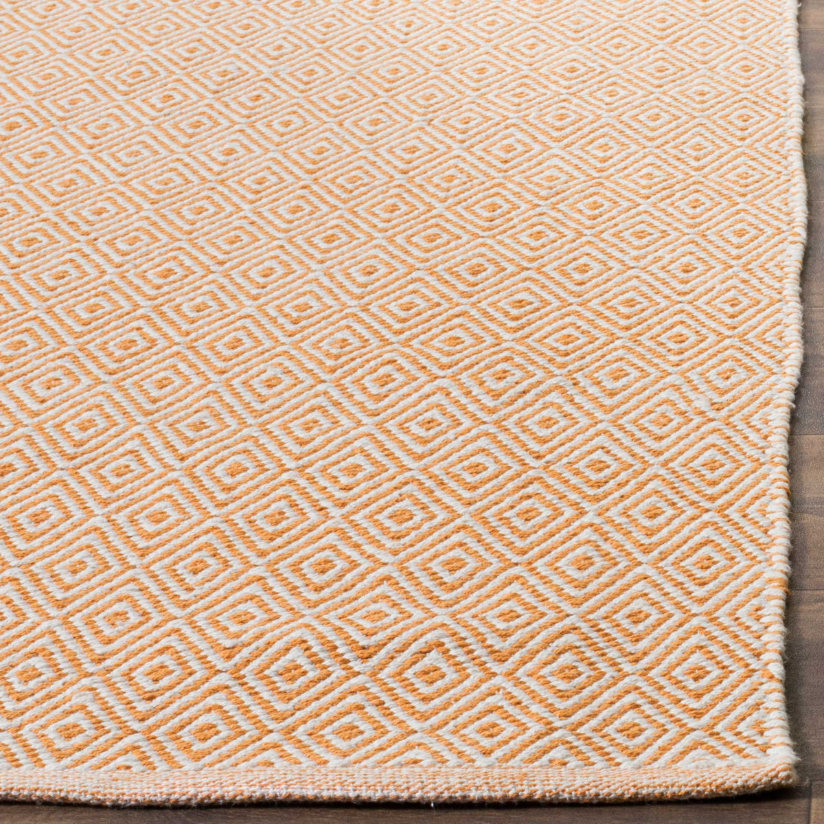 Textured rust and ivory diamonds meet a neat woven edge on this cotton rug