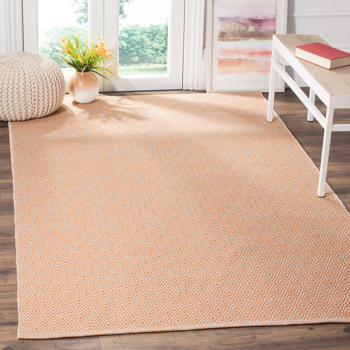 The warm rust and ivory diamond rug enlivens a bright living area