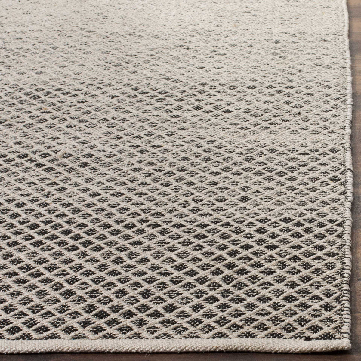 Black diamond motifs stand out against ivory cotton, framed by a neatly finished edge.