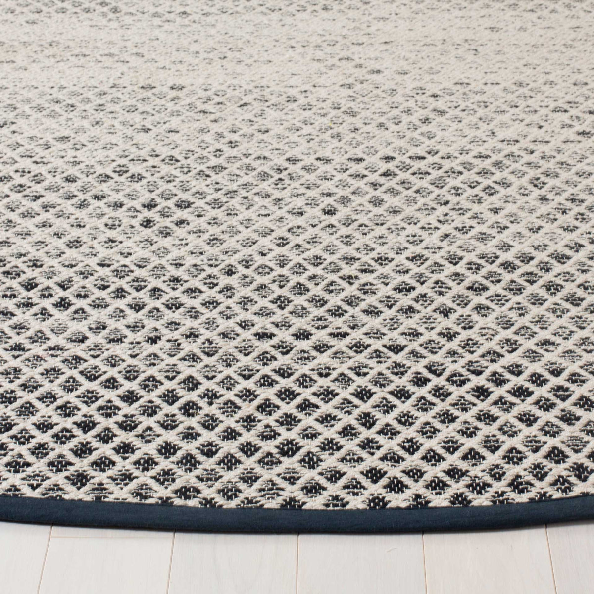 Woven black diamonds stand out against ivory cotton above a crisp, dark bound edge