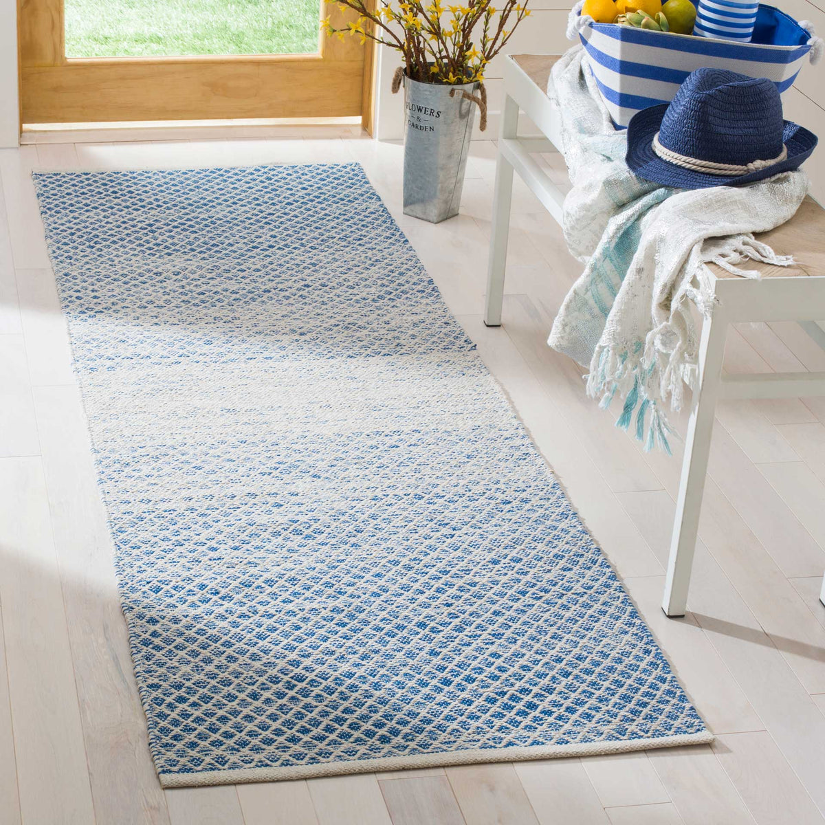 Cool blue and ivory runner brightens a pale entryway with a softly fading geometric design
