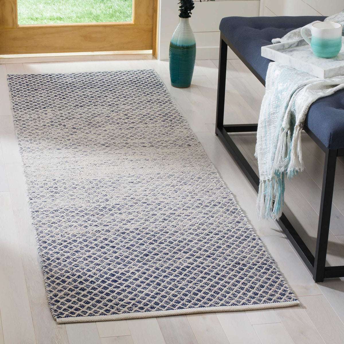 Navy and ivory geometric runner anchors a bright entryway with a softly faded center