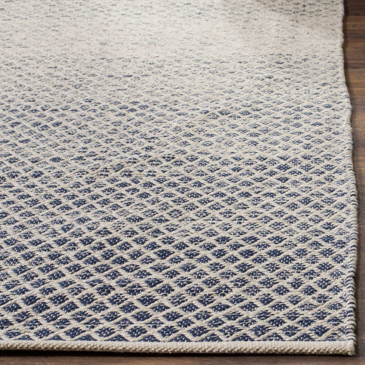 Navy diamond motifs pop against ivory cotton with a neatly bound edge.