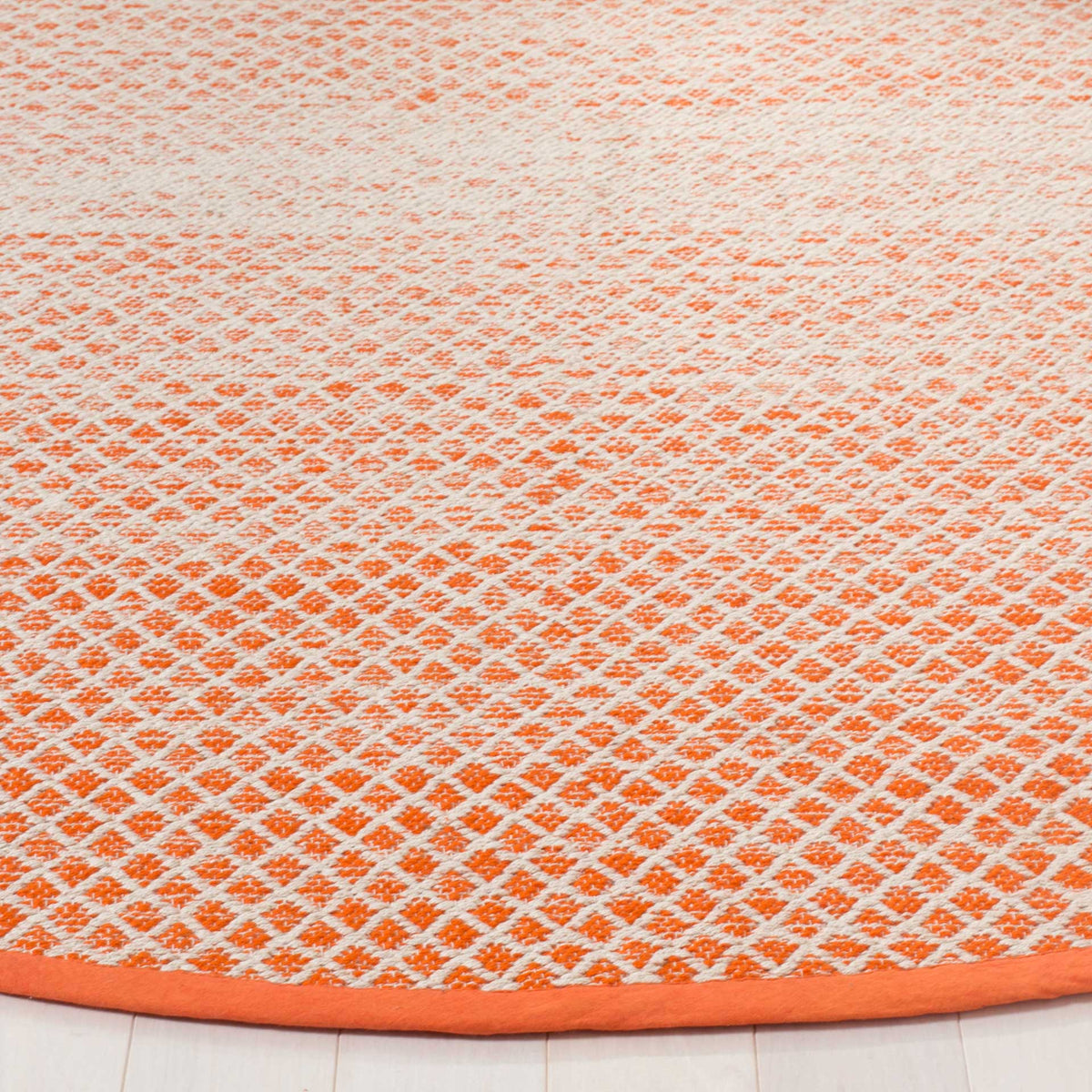 Bright orange diamonds pop against ivory cotton beside a smooth orange bound edge