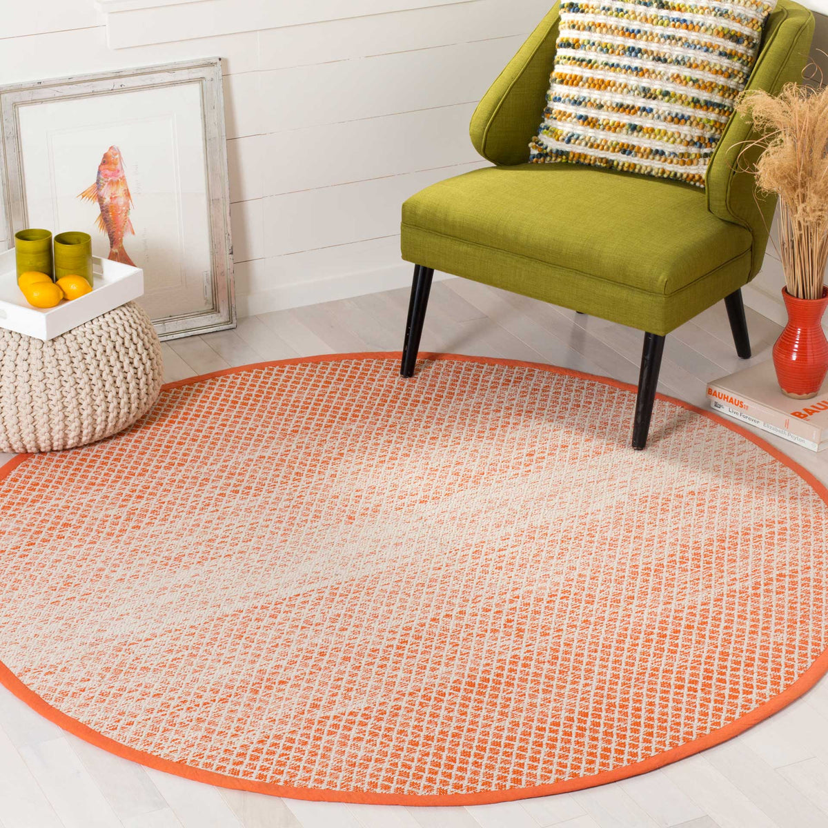 Orange and ivory round rug brightens a seating nook with warm color and intricate geometry
