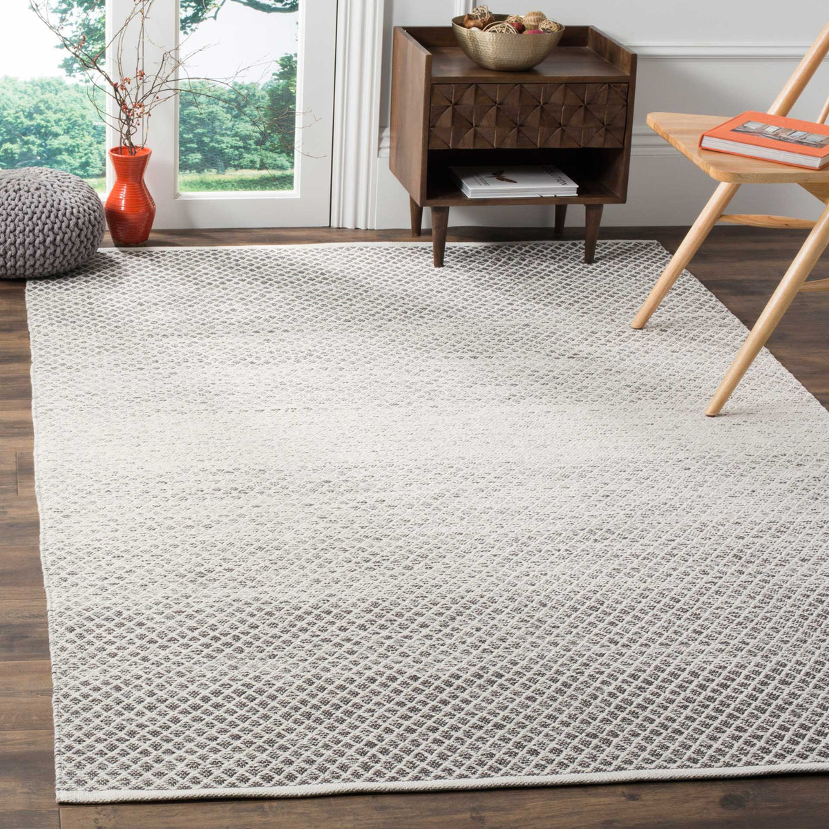 Gray and ivory diamondwork adds subtle texture beneath furniture, with a softly faded center.